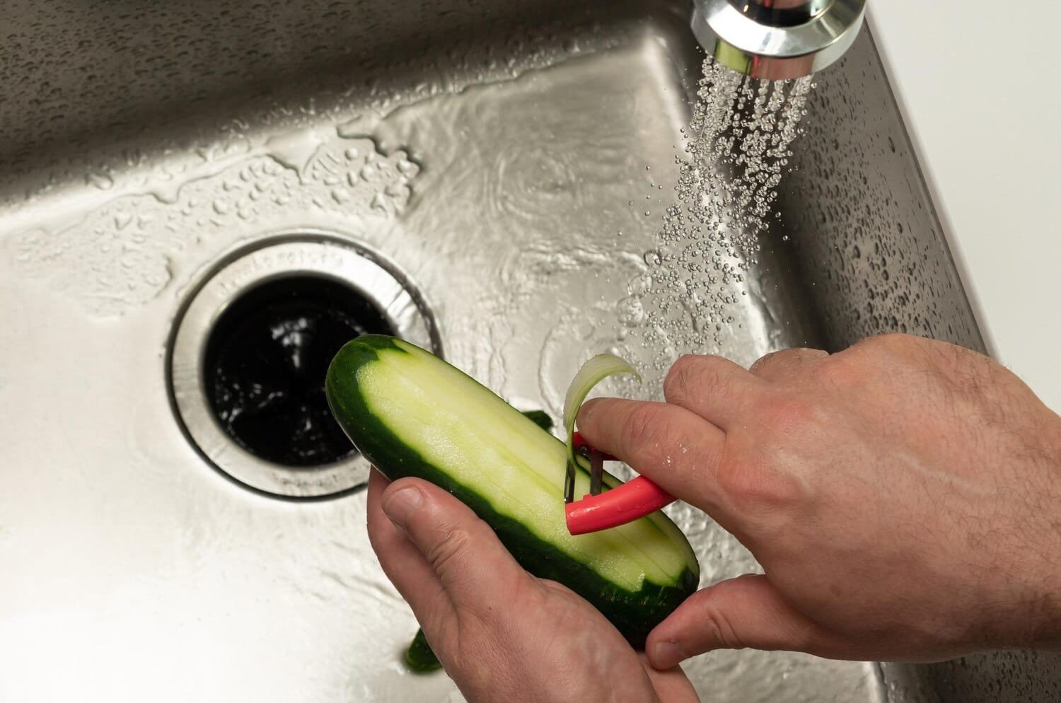 half peeled cucumber sink male hands top view 1046379 2259